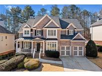 Charming two-story brick home with a welcoming front porch and a well-manicured lawn at 1775 Unity Loop, Cumming, GA 30040
