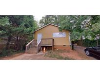 Charming exterior of a one-story home with a wooden porch, showcasing its inviting facade and front yard at 45 James P Brawley Nw Dr, Atlanta, GA 30314