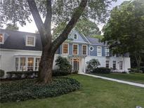 Charming two-story home with white brick and blue accents, complemented by lush greenery at 499 Johnson Ferry Nw Rd, Atlanta, GA 30328
