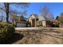 Charming brick home featuring a well-manicured lawn and attached two car garage with ample driveway parking at 1520 Camden Cove Dr, Cumming, GA 30040