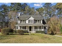 Charming two-story home featuring a welcoming front porch and well-manicured lawn surrounded by mature trees at 928 Gate Post Ln, Lawrenceville, GA 30044