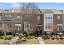 Charming brick townhome with manicured landscaping, featuring a welcoming front entrance and symmetrical facade at , Duluth, GA 30096