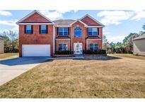 Traditional two-story brick home with an attached garage and large front lawn at 4970 Wewatta Sw St, Atlanta, GA 30331