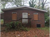 Quaint brick home with a traditional design and a cozy front porch and boarded windows at 511 Elmwood Nw Rd, Atlanta, GA 30318