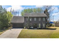 Two-story home featuring black siding, an attached garage, and a well-manicured front yard at 1970 Furlong Run, Lawrenceville, GA 30043