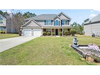 Charming two-story home featuring a well-manicured lawn and a two-car garage at 63 Shadowhill Ct, Loganville, GA 30052
