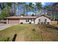 Charming single-story home with a well-manicured lawn, stone accents, and an attached two-car garage at 3776 Bromolow Trl, Lawrenceville, GA 30044