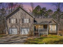 Charming two-story home with a front porch and a two-car garage and tan siding and shutters at 321 Oak Landing Cir, Douglasville, GA 30134