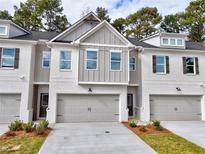 Charming townhome featuring a gray garage door and a white brick exterior with gray accents at 5425 Rock Place Ct # 37, Norcross, GA 30093