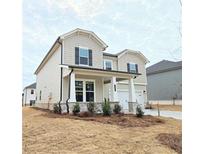 Charming two-story home featuring a welcoming front porch with stone accents and a two car garage at 2654 Mourning Dove Drive (Lot 39), Grayson, GA 30017