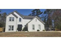 Charming two-story stucco home featuring a well-manicured lawn and elegant architectural details at 4215 Idle Grass Pl, Cumming, GA 30041