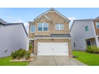 Charming two-story home featuring a stone and brick facade with an attached two-car garage at 826 Bentley Dr, Fairburn, GA 30213