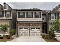 Charming townhome with stone accents, two-car garage, and neutral color palette at 257 Stone Park Dr, Woodstock, GA 30188