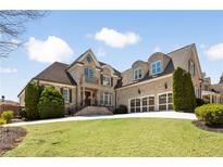 Stately brick home with manicured lawn, three-car garage and inviting entryway at 2770 Wooded Hills Walk, Marietta, GA 30062