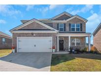 Charming two-story brick home with a well-manicured lawn and a two-car garage at 294 Broder Farms Dr, Stockbridge, GA 30281