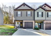 Charming townhome featuring a well-manicured lawn, a garage, and a welcoming front porch at 1709 Creel Ln, Atlanta, GA 30349