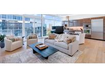Bright living room with large windows, modern furniture, and a sleek kitchen in the background at 45 Ivan Allen Jr Nw Blvd # 1704, Atlanta, GA 30308
