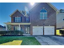 Charming two-story brick home featuring a well-maintained lawn and a two-car garage at 4590 Carver Ct, Cumming, GA 30040