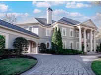 Elegant home showcases a circular driveway, gray paint, and stately columns for a grand entrance at 3594 Tuxedo Nw Ct, Atlanta, GA 30305