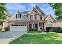 Charming two-story brick home featuring a two-car garage, manicured lawn, and classic architectural details at 106 Little Barley Ln, Grayson, GA 30017