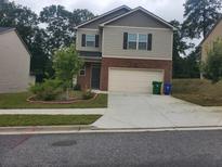 Two-story home featuring brick accents, a two-car garage, and a well-manicured front yard at 3198 Allison Cir, Decatur, GA 30034