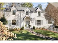 Charming white brick home featuring a stone walkway, manicured lawn, and welcoming front door at 3800 Wieuca Ne Ter, Atlanta, GA 30342