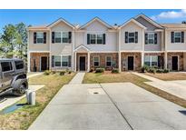 Inviting townhouse exterior featuring brick accents and a well-maintained lawn at 6036 Oakley Rd, Union City, GA 30291