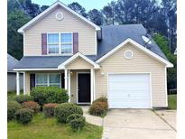 Charming two-story home featuring a garage, well-manicured front yard, and welcoming entryway at 150 Victoria Blvd, Oxford, GA 30054