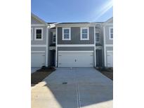 Modern townhome featuring a two-car garage and neutral gray siding with white trim at 5189 Longview Run, Decatur, GA 30035