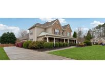 Charming two-story home features a welcoming front porch, well-manicured lawn and lush landscaping at 1527 Sage Ridge Dr, Marietta, GA 30064