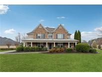 Charming two-story brick home with a covered front porch and manicured lawn at 1527 Sage Ridge Dr, Marietta, GA 30064