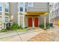 Townhouse exterior featuring a sidewalk leading to two red front doors under a shared, covered entrance at 808 Riverview Se Dr, Marietta, GA 30067