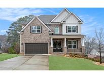 Charming brick home with a two-car garage, manicured lawn, and welcoming covered front porch at 3139 Hilltop Dr, Marietta, GA 30066