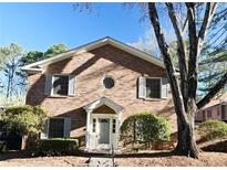 Traditional brick home with a symmetric facade, complemented by mature trees and manicured shrubs at 3338 York Pl, Decatur, GA 30032