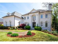 Elegant white brick home boasts meticulous landscaping, a manicured lawn, and a classic design at 948 Saint Lyonn Cts, Marietta, GA 30068