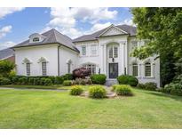 Stunning white brick home featuring manicured landscaping, a well-maintained lawn, and a welcoming entrance at 948 Saint Lyonn Cts, Marietta, GA 30068