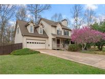 Charming two-story home with a manicured lawn, flowering tree, and an attached two-car garage at 7810 Rose Ct, Cumming, GA 30040