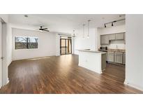 Bright open-concept living room with wood floors, modern light fixtures, and access to a private balcony at 2230 Cheshire Bridge Ne Rd # 410, Atlanta, GA 30324