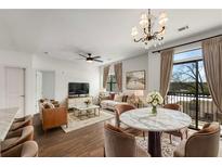 Bright living room with hardwood floors, a chandelier, balcony access, and modern furniture at 2230 Cheshire Bridge Ne Rd # 410, Atlanta, GA 30324