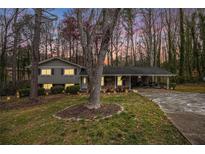 Charming one-story home with a well-manicured lawn and a covered parking area at 5140 Cowart Ct, Powder Springs, GA 30127