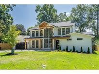 Stunning two-story home with a modern design, lush lawn, and eye-catching natural wood elements at 1653 Pamela Ne Dr, Brookhaven, GA 30319