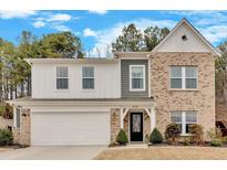 Charming two-story home with a brick facade, white accents, and a well-manicured front yard at 6530 Lantana Village Way, Cumming, GA 30028