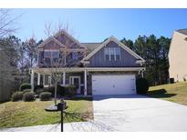 Charming two-story home with a two-car garage, beautiful landscaping, and a well-maintained front yard at 667 Rockingham Dr, Lithia Springs, GA 30122
