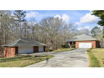 A red brick house and detached two-car garage on a large lot at 5595 Rolling Acres Ln, Cumming, GA 30028