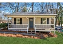Charming home featuring a covered front porch, neutral siding, black shutters, and a well-maintained lawn at 6165 Short St, Canton, GA 30114
