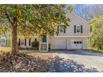 Charming home featuring a two car garage, traditional siding, and black shutters at 1270 Della Way, Lawrenceville, GA 30043