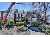 Charming townhomes featuring a gazebo entrance, lush landscaping, and well-maintained brick facades at 3495 Tulip Tree Ln, Duluth, GA 30096