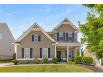 Charming two-story home with neutral siding, black shutters, manicured lawn, and inviting front porch at 207 Cross Rd, Acworth, GA 30102