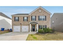 Charming two-story brick home with attached two-car garage and well-maintained front yard at 3464 Enterkin Ln, Atlanta, GA 30349