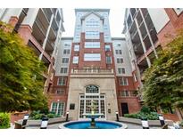 Elegant brick condominium building featuring a central water fountain and manicured landscaping at 50 Biscayne Nw Dr # 6111, Atlanta, GA 30309